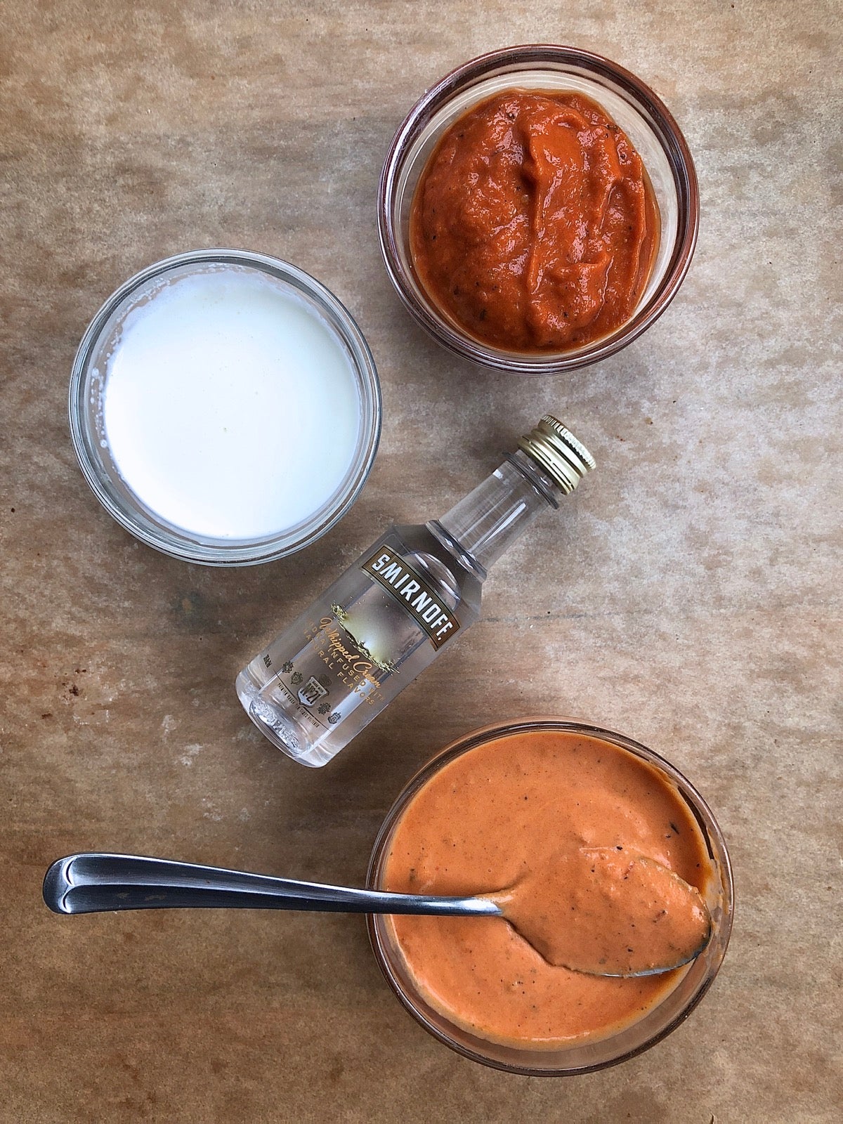 Ingredients for pink vodka sauce, including vodka, tomato sauce, and heavy cream.